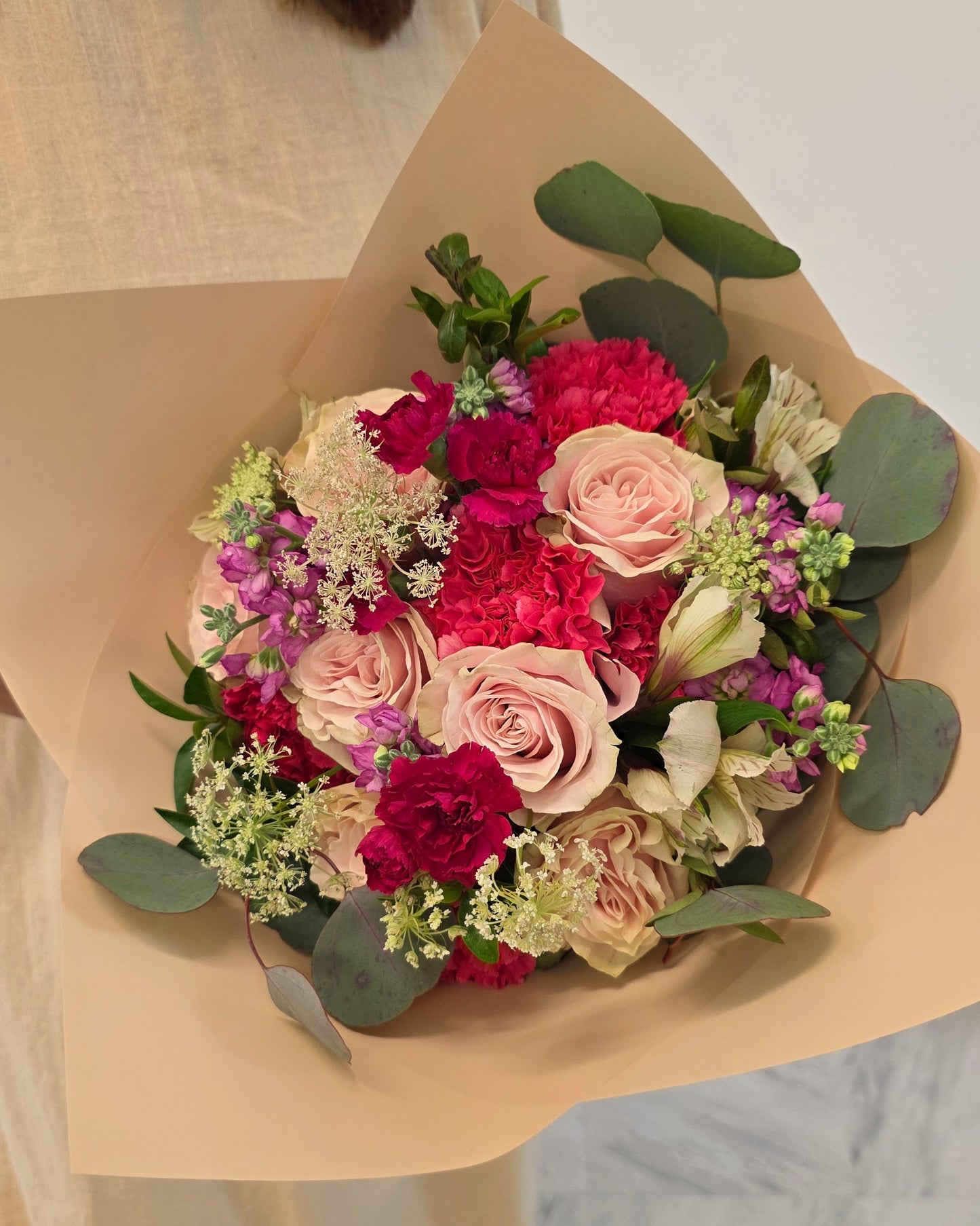 Photo of a woman holding a colorful hand-tied bouquet
