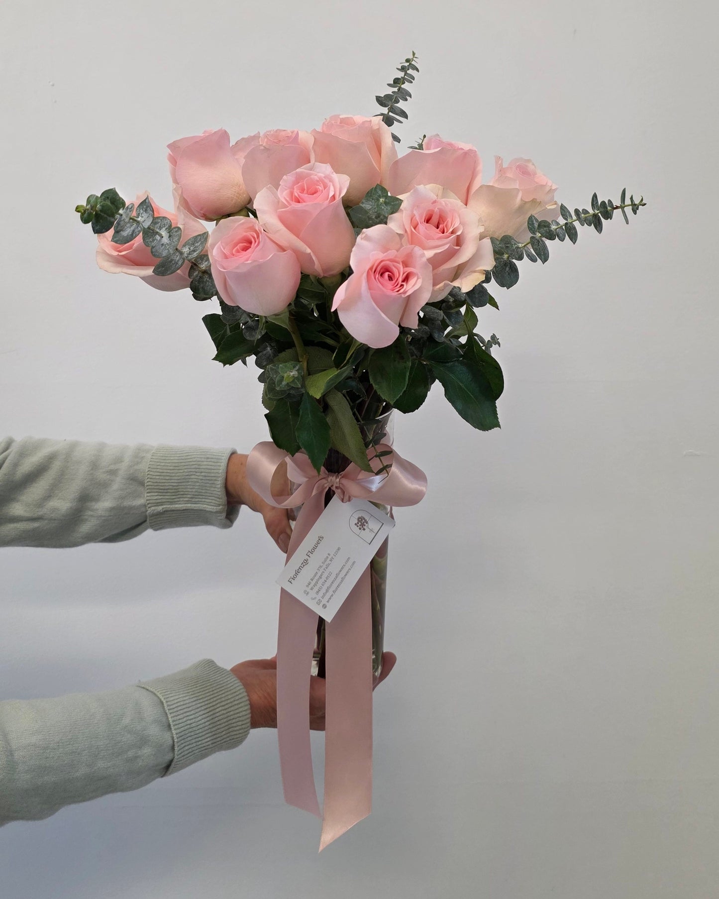 Photo of a woman holding an arrangement of pink roses