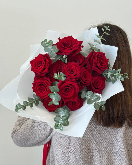 Photo of a woman holding a hand-tied bouquet of red roses